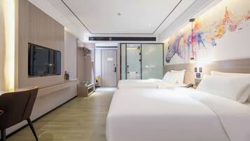 Habitación de hotel con una cama grande, televisión, escritorio y pared divisoria de vidrio.