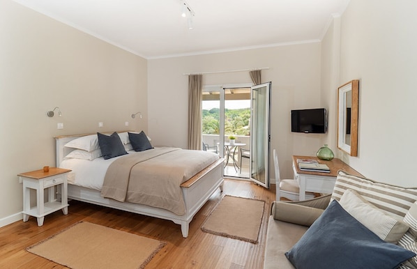 A bedroom with a bed, bedside table, and a TV. - Bella Mare Hotel (Corfu)