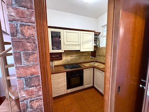 A compact kitchen with white cabinets, a stove, and a dishwasher. - Apartment House Ammura Balcony Garden (Tignale)