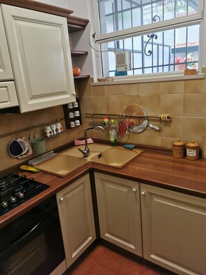 A kitchen with a double sink, stove, oven, and cabinets. - Apartment House Ammura Balcony Garden (Tignale)