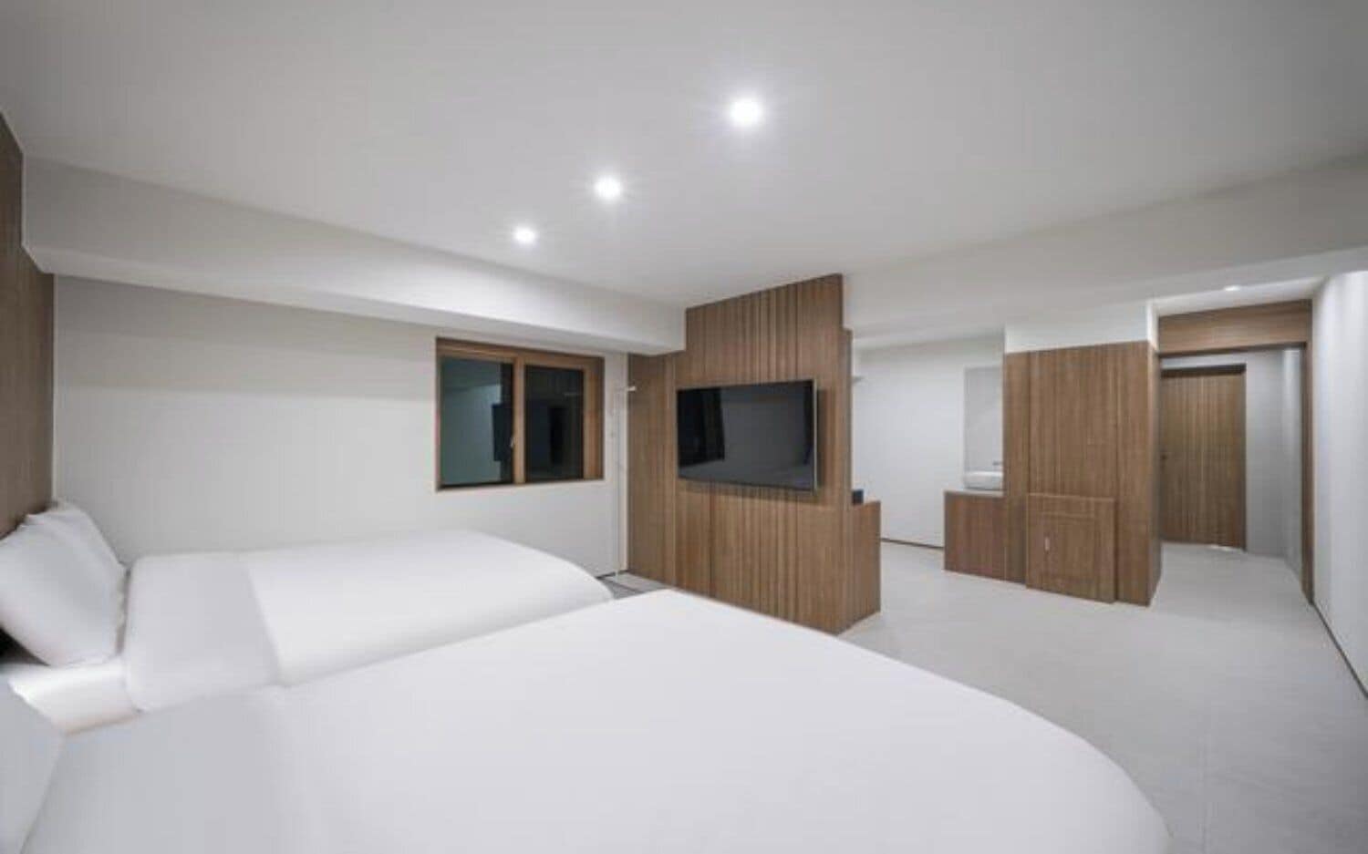 Una camera da letto moderna con un letto grande, una TV e armadi a muro.
