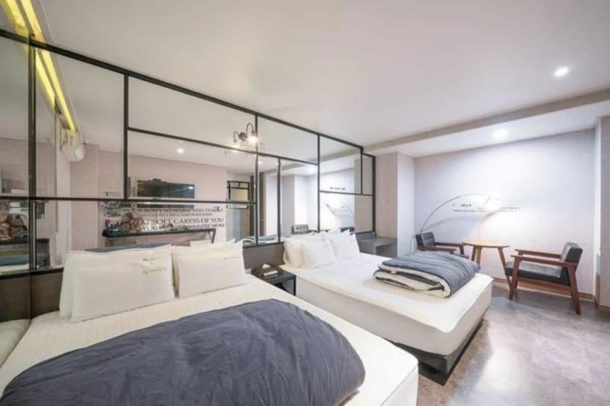 Una habitación de hotel moderna con una cama grande, un escritorio y una silla.