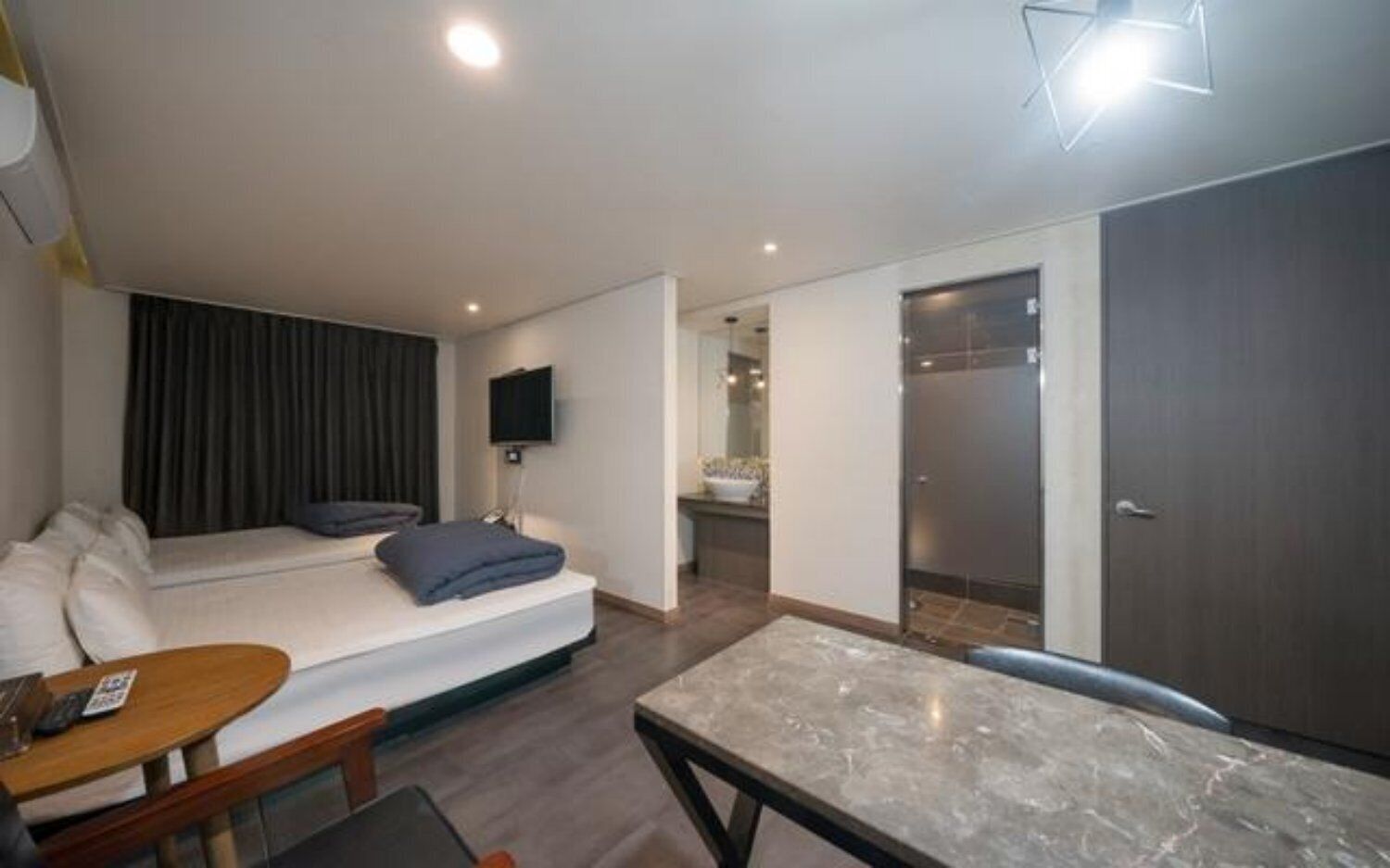 Une chambre d’hôtel moderne équipée d’un lit, d’une télévision, d’un bureau et d’une salle de bain.