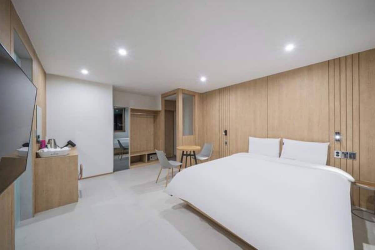Un dormitorio moderno con una cama grande, un escritorio y una silla.