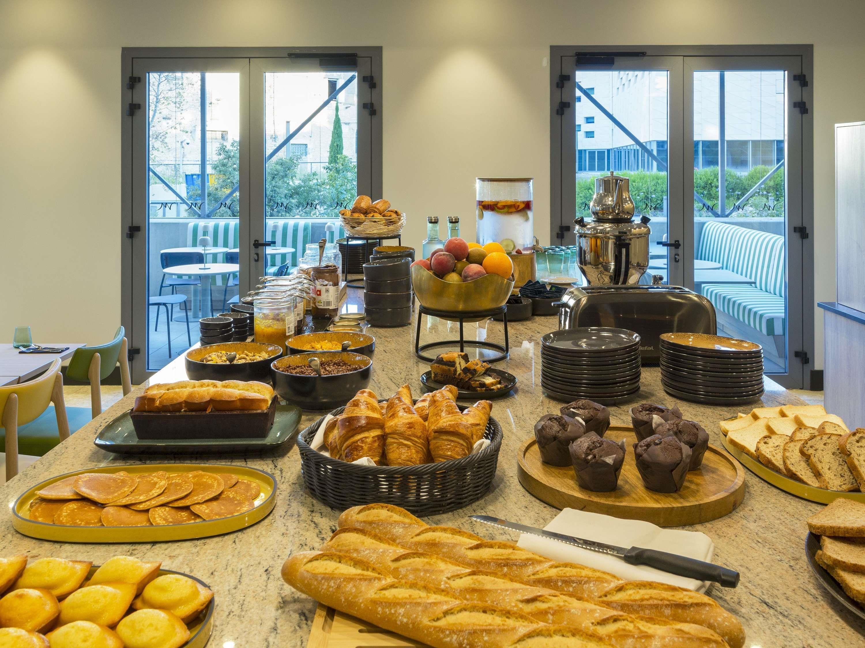 Un buffet proposant une variété de pains, de viennoiseries et de fruits.