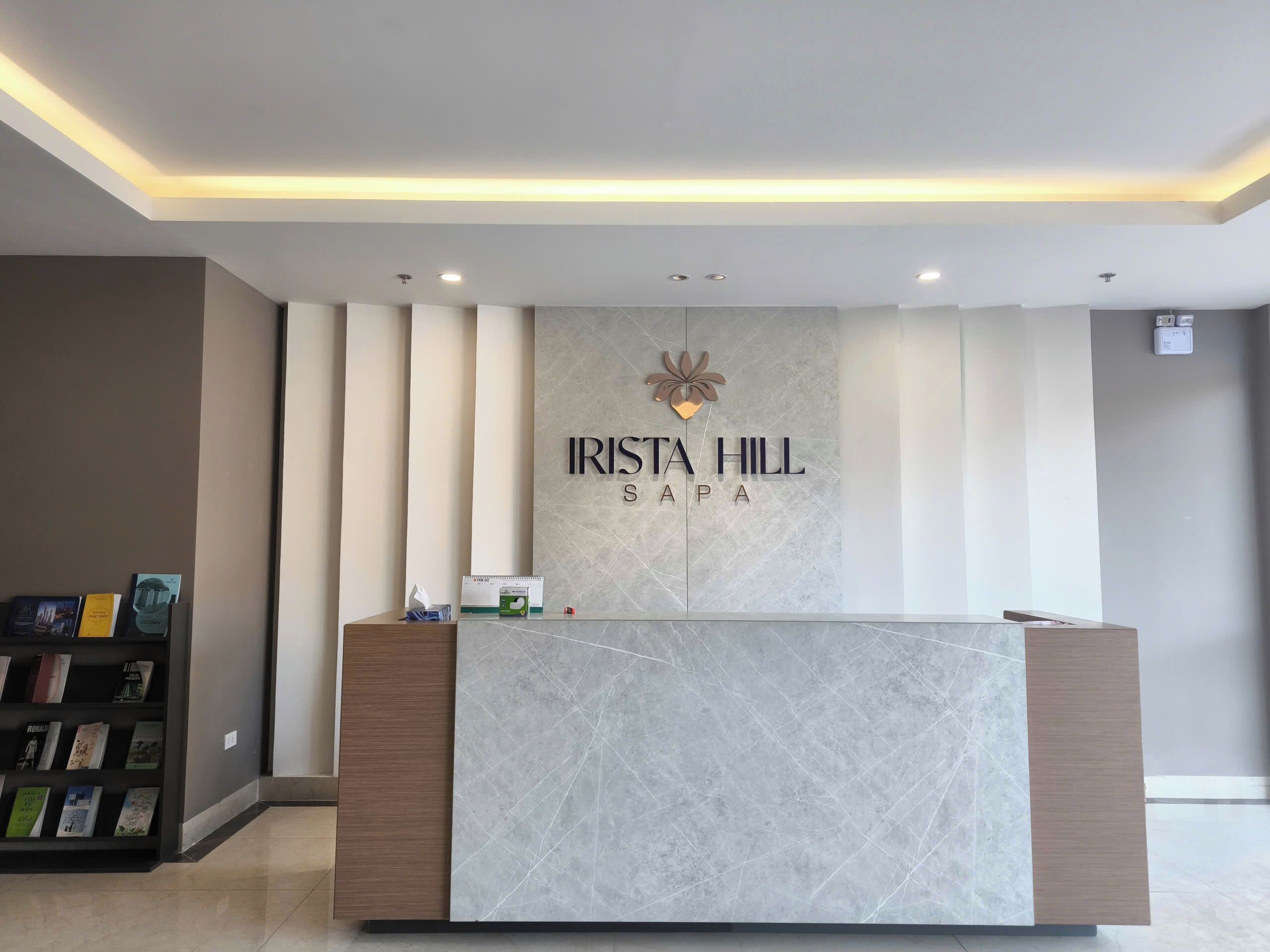 A reception desk with a marble top and a logo above it.