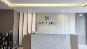 A reception desk with a marble top and a logo above it.