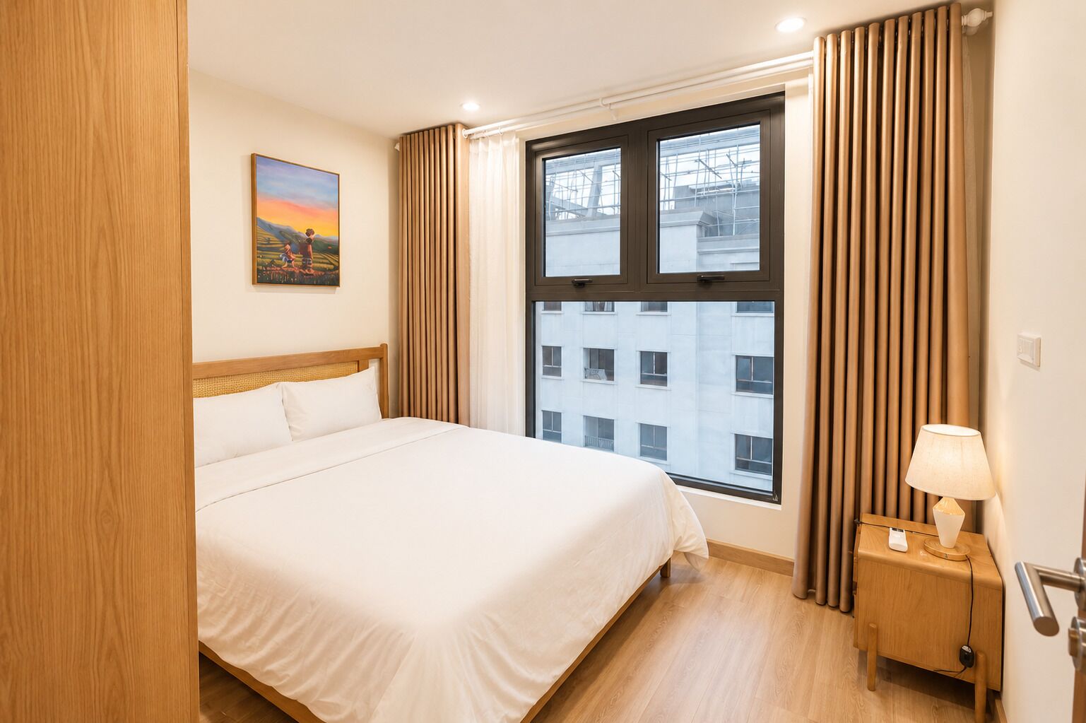 A hotel room with a bed, a nightstand with a lamp, a window with curtains, and a painting on the wall.