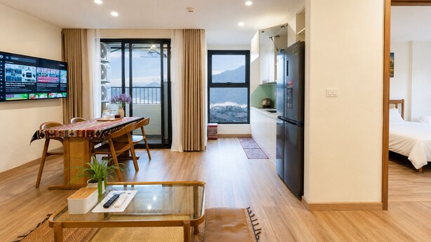 Quarto de hotel moderno com varanda, área de refeições, cozinha e cama.