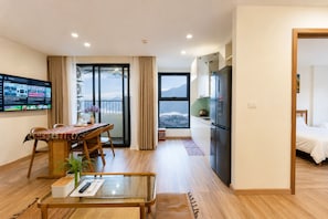 Una camera d'albergo moderna con balcone, angolo ristoro, cucina e letto.