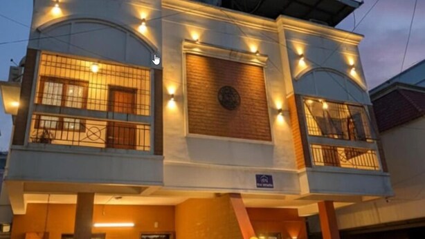 A two-story building with a balcony on the upper floor, a visible door on the ground floor, and a sign indicating a handicap-accessible entrance. - The Sheltor (Chennai)