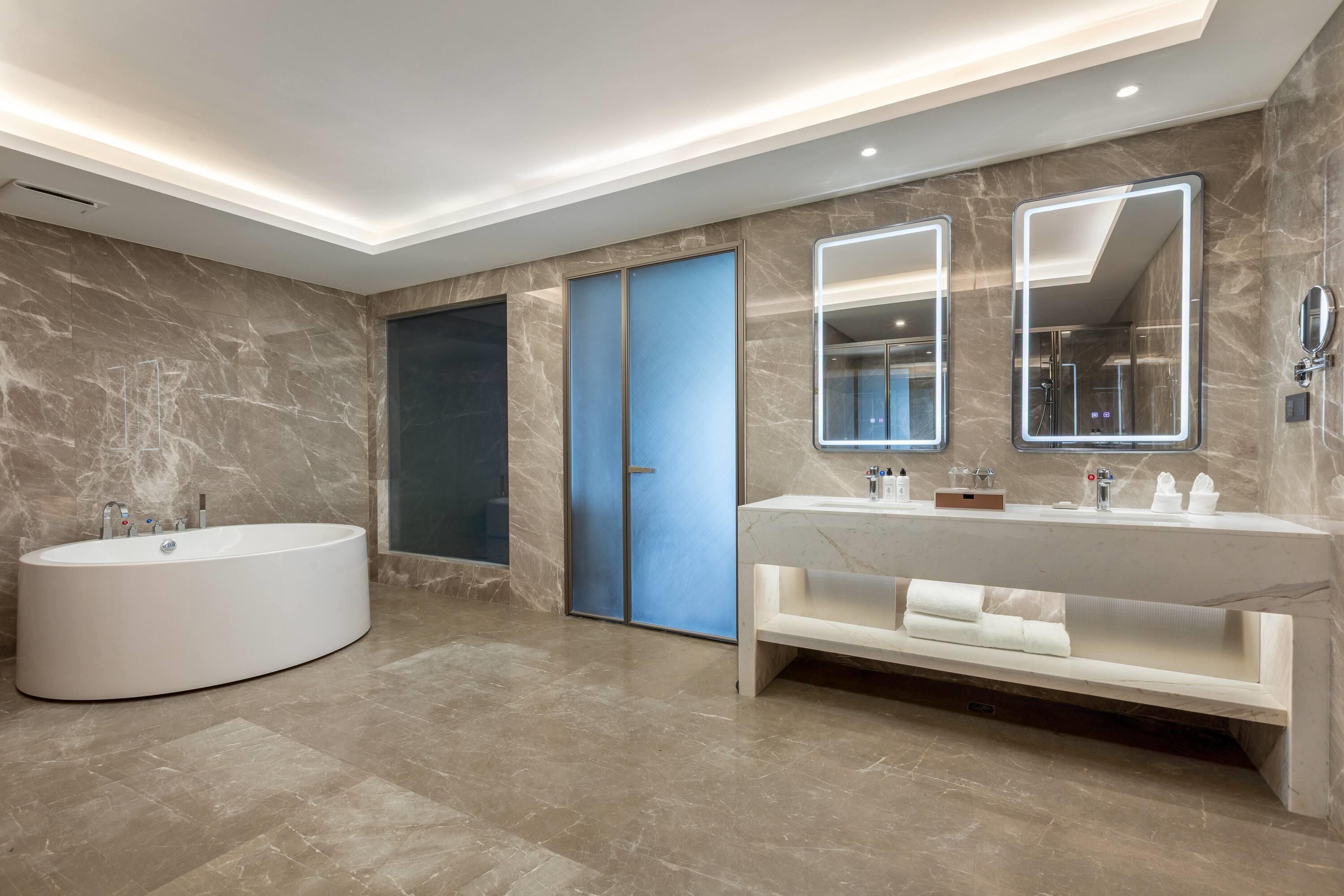 Un baño moderno con una bañera independiente, un tocador con espejo y una zona de ducha.