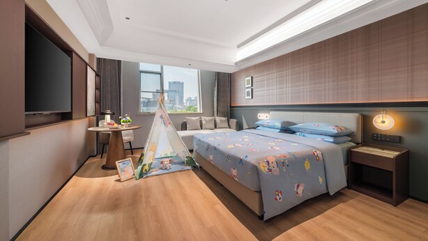 A modern hotel room with a large bed, a desk, a tent, and a city view. - Genpla Hotel by Shenzhen Metro (Shenzhen)