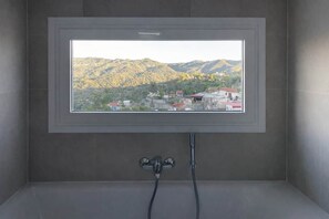 Een badkamer met uitzicht op een bergachtig landschap.