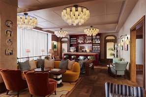 Un vestíbulo de hotel con zona de bar, asientos y una iluminación decorativa.