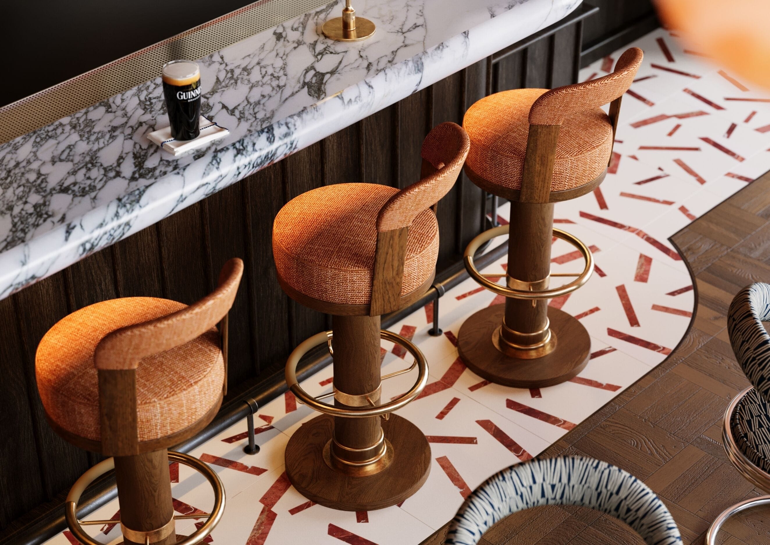 Un coin bar avec trois tabourets, un comptoir en marbre et un sol à motifs.