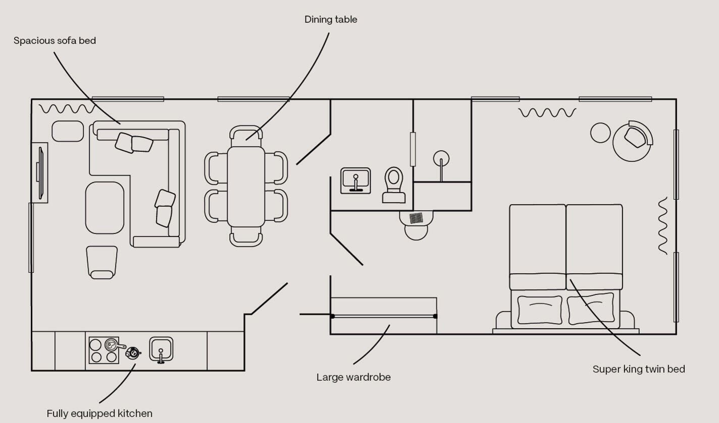 A floor plan of a hotel room with a spacious sofa bed, a fully equipped kitchen, a dining table, a large wardrobe, and a super king twin bed.
