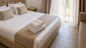 Una camera d'albergo con un letto, un comodino, un condizionatore d'aria e vista dalla finestra.