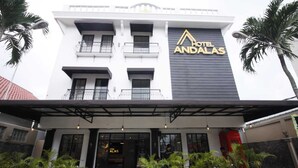 Ein Hotel namens 'Hotel Andalalas' mit einer modernen Fassade, Balkonen und Außenbestuhlung.