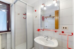 A bathroom with a glass shower enclosure, a white sink, and a mirror with integrated lighting. - Apartment 'Casa Fiori a Vinigo' with Mountain View and Balcony (Vinigo)
