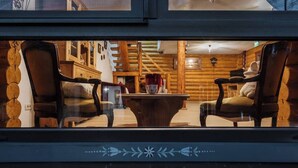 Un intérieur chaleureux avec des murs en bois, une table centrale et deux chaises.
