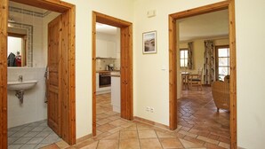 A hallway with wooden doors leading to a bathroom, kitchen, and dining area. - Modern and comfortable vacation home - Reethaus Wiek left half of the house (Wiek)