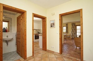 A hallway with wooden doors leading to a bathroom, kitchen, and dining area. - Modern and comfortable vacation home - Reethaus Wiek left half of the house (Wiek)