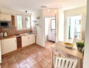 A compact kitchen with a microwave, sink, and wooden cabinets.