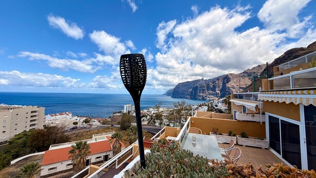A coastal view with a prominent black sculpture, buildings, and a clear sky. - 2 BD Apartment with stunning view (Acantilados de los Gigantes)