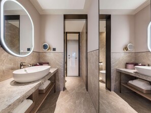 A modern bathroom with two sinks, marble flooring, and a large mirror.