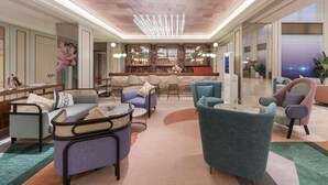 Un amplio salón con techo alto, un bar con vistas y asientos cómodos.