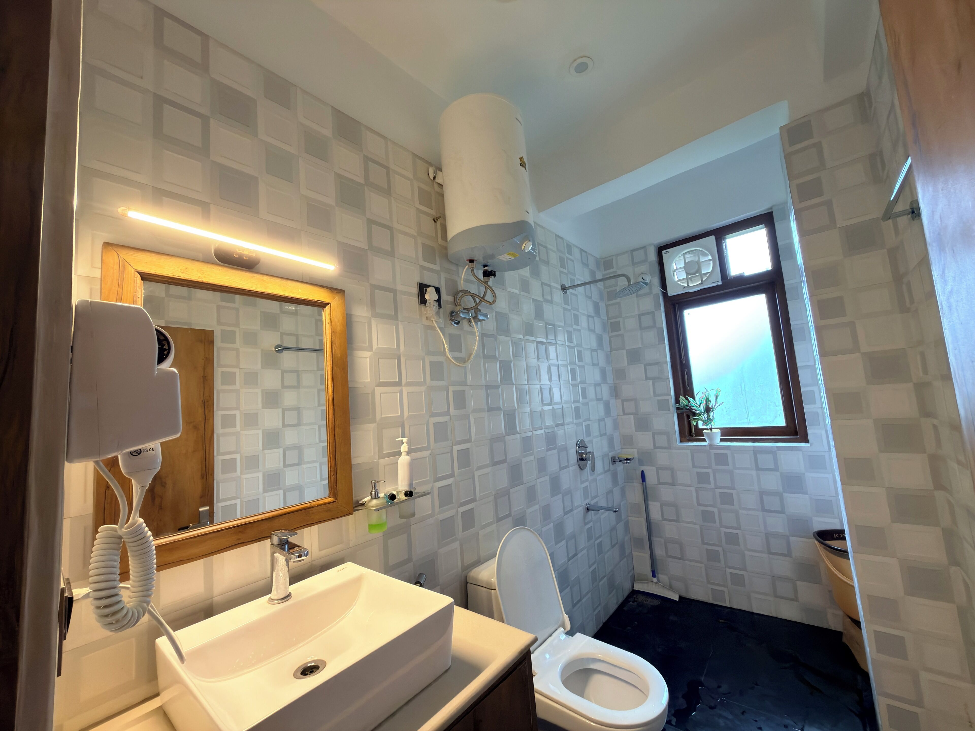 Une salle de bain équipée d’un lavabo, de toilettes, d’un miroir et d’une douche.