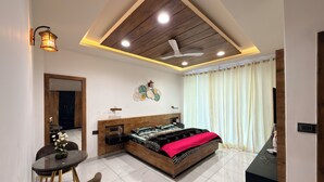 Une chambre moderne avec un lit, un bureau, une chaise et un ventilateur de plafond.