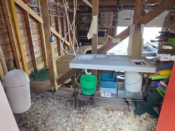A rustic wooden interior with a workbench, storage bins, and a pegboard with tools.