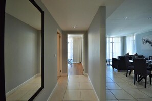 A modern interior with a hallway leading to a dining area. - Icon Apartments - Airscape (Cape Town)