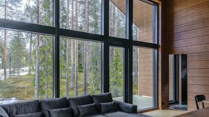 A modern interior with large windows, a sofa, and a wooden wall.