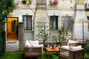 A courtyard with wicker furniture, a small table with glasses, and a door marked '946'. - Your Private Garden - Cà de l'Astrologo (Venezia)