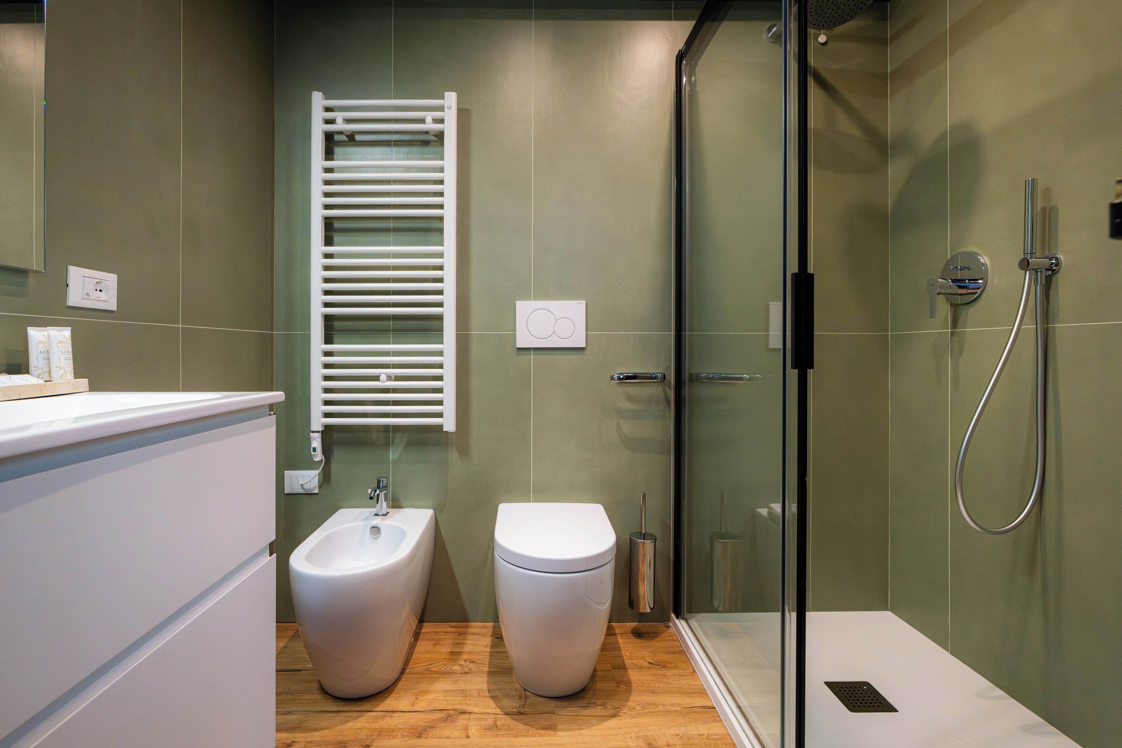 Ein modernes Badezimmer mit integriertem Bidet, Toilette und Duschkabine.