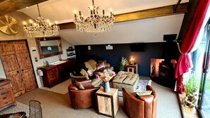 A living room with a chandelier, wooden furniture, a sofa set, and a fireplace. - The View, Luxury Retreat, Outstanding views over the countryside & Hebden Bridge (Cragg Vale)