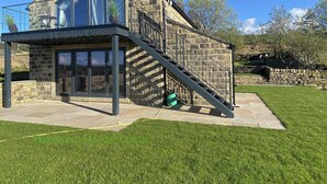 A stone cottage with a glass balcony, a staircase, and a grassy yard. - The View, Luxury Retreat, Outstanding views over the countryside & Hebden Bridge (Cragg Vale)