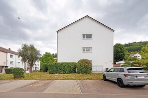 A residential building with a flat roof and two windows.