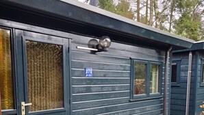 Un edificio scuro con una porta, una finestra e un cartello con un numero.