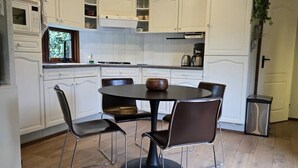 Una cucina moderna con mobili bianchi, un tavolo rotondo e quattro sedie.