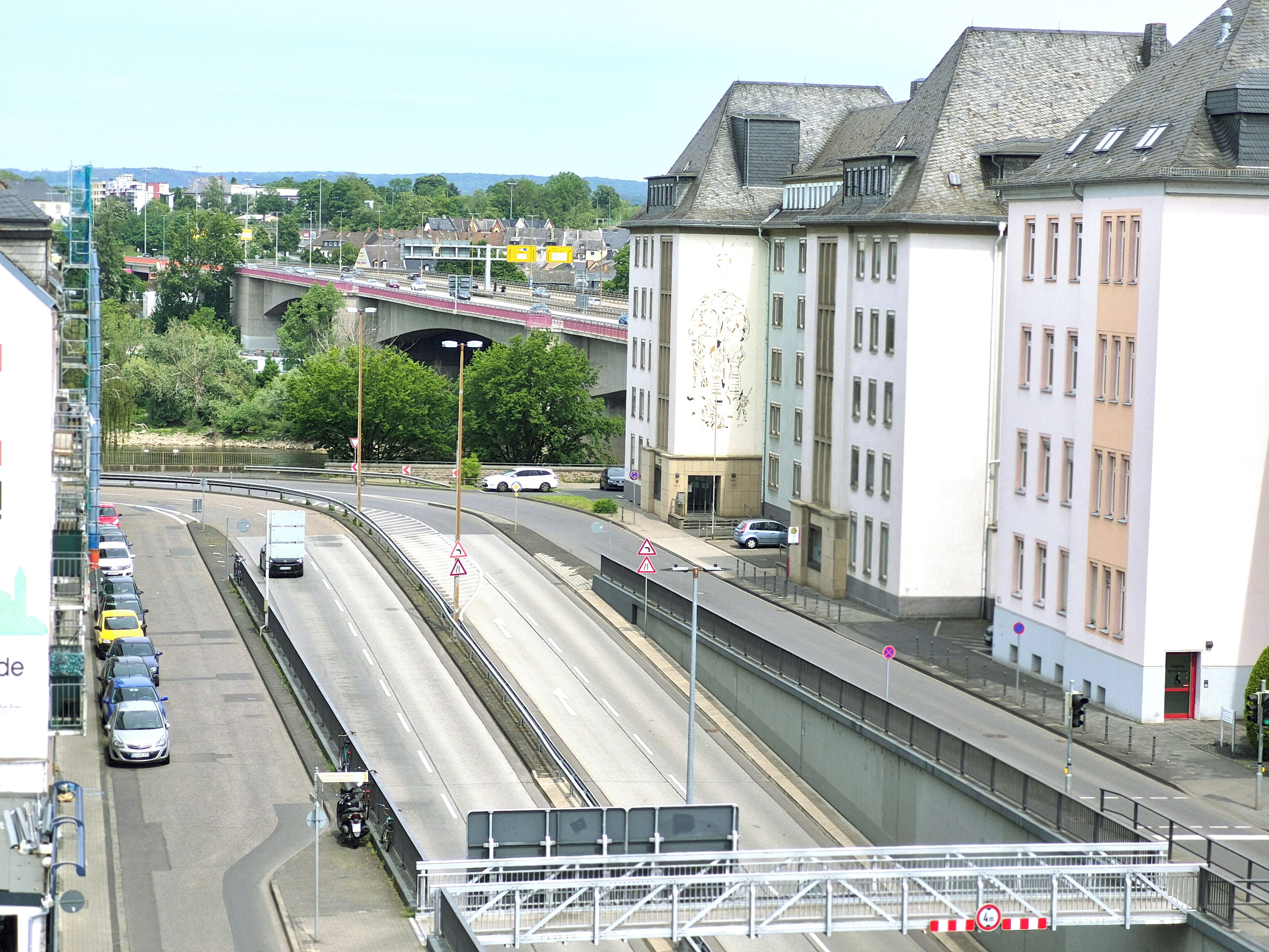 A multi-level highway with vehicles, a pedestrian bridge, and buildings with uniform windows.