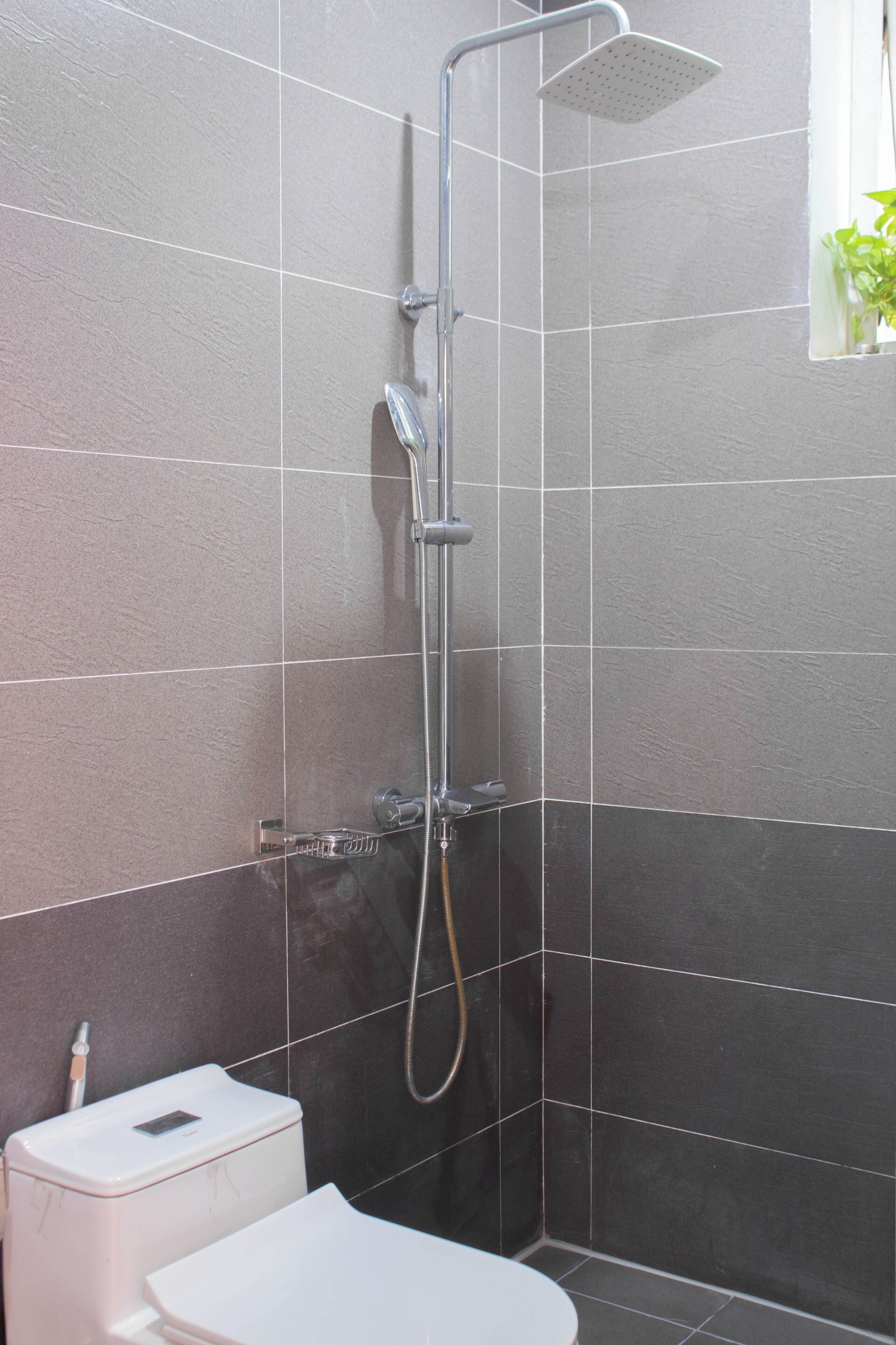 A bathroom with a shower, a toilet, and a sink.