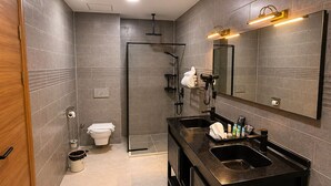 Une salle de bain moderne équipée d’une douche, de toilettes et d’un meuble-lavabo avec un miroir et un évier.