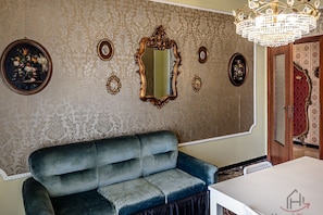 A room with a blue sofa, a white table, a large mirror, and a chandelier. - [Sea 400m]• Free Parking • WiFi (Varazze)