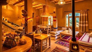 A cozy interior with a fireplace, wooden furniture, and a staircase. - Riad Pizzeria Marhaba (Ait Sedrate Jbel El Soufla)