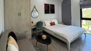 Une chambre à coucher comprenant un lit, un bureau, une chaise, un canapé et une armoire.