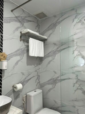 Een douche, een haardroger, een bidet, handdoeken